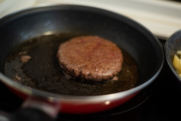 Cooking meat and fries in oily saucepan   