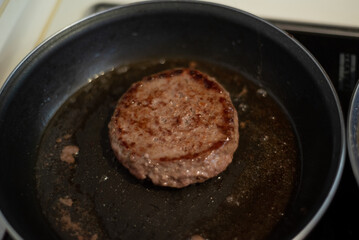 Cooking meat and fries in oily saucepan   