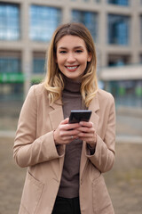 Fototapeta na wymiar Portrait of young business woman using phone outdoors