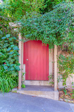 Arched Wooden Red Door Gate With Arbor Roof At The Front In San Francisco, California