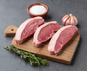 Sliced raw picanha or rump meat over wooden board with seasonings