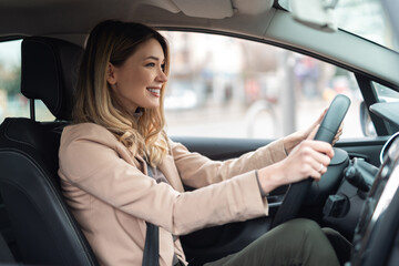 Young beautiful woman driver sitting in car, driving