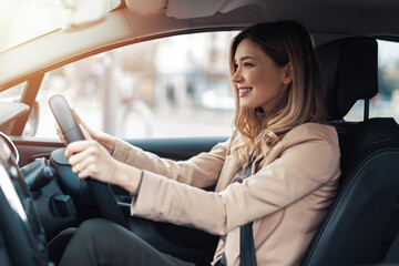 Young beautiful woman driver sitting in car, driving