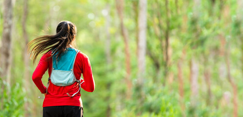 Asian women middle aged running at morning forest trail outdoor exercise © mnirat