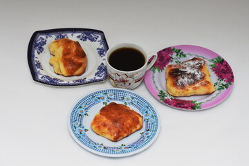 Breakfast -  porcelain platte  with croissant  and a cup of coffee  on black background
