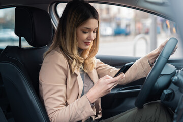 Young female driver looking at her phone