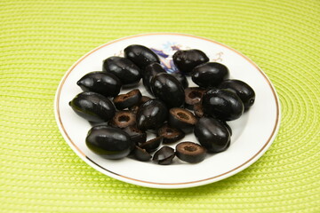 black olives on a  porcelain plate 