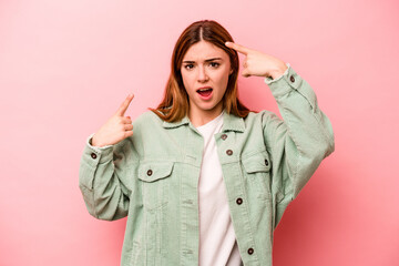 Young caucasian woman isolated on pink background showing a disappointment gesture with forefinger.