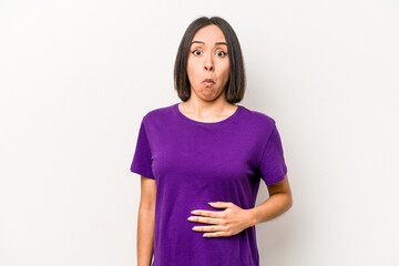 Young hispanic pregnant woman isolated on white background shrugs shoulders and open eyes confused.