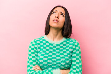 Young hispanic woman isolated on pink background tired of a repetitive task.