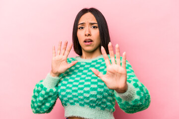 Young hispanic woman isolated on pink background being shocked due to an imminent danger