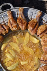 crispy chicken and fried potatoes on a cast iron disk