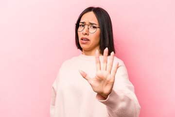 Young hispanic woman isolated on pink background being shocked due to an imminent danger