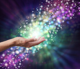 Magical Energy Healing Hands Concept - sparkling and bokeh background with a female open palm in...