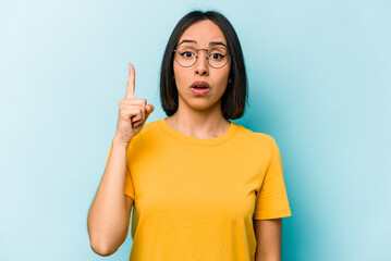 Young hispanic woman isolated on blue background having an idea, inspiration concept.