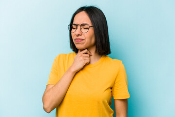 Young hispanic woman isolated on blue background suffers pain in throat due a virus or infection.