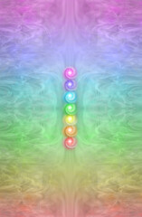 Simple Seven Chakra Diagram background - multicoloured graduated rainbow coloured symmetrical pattern background with 7 chakra stack placed centrally and copy space all around

