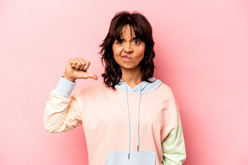 Young hispanic woman isolated on pink background showing a dislike gesture, thumbs down. Disagreement concept.