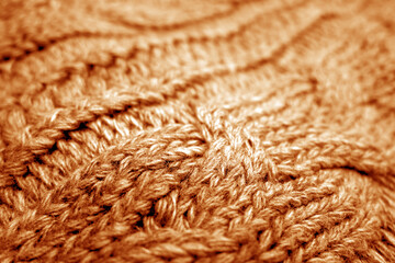 Warm knitting texture with blur effect in orange tone.