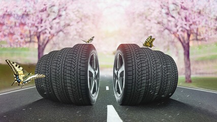  Car tires standing on the road against sun light of headlights in spring. - obrazy, fototapety, plakaty