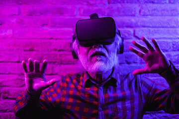 Obraz premium Asian senior man having fun using futuristic 3d goggles - Concept of technology