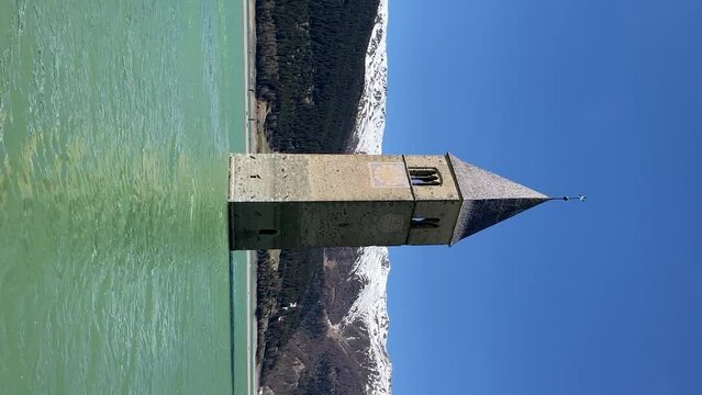 The bell tower of the sunken village in the lake Resia, vertical video