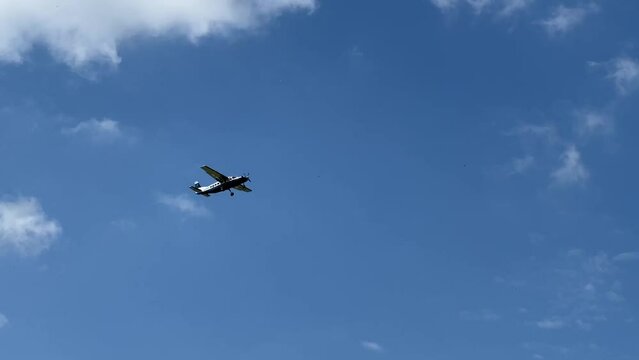 Cessna 208b Grand Caravan G-CPSS light aircraft ascending from take off in a blue sky white cloud on a flight to drop parachutists