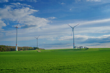 Fototapeta na wymiar Panoramic view of wind farm or wind park on sunny day, with high wind turbines for generation electricity with copy space. Green energy concept.