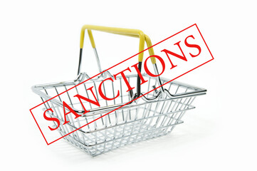 the word sanctions and an empty iron shopping basket in a supermarket on a white background is...