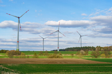 Fototapeta na wymiar Panoramic view of wind farm or wind park on sunny day, with high wind turbines for generation electricity with copy space. Green energy concept.