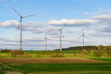 Panoramic view of wind farm or wind park on sunny day, with high wind turbines for generation electricity with copy space. Green energy concept.