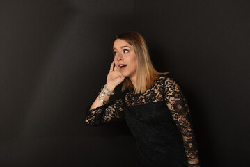 bellissima ragazza in abito di pizzo nero che origlia