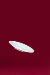 Flying White Porcelain plate on red background