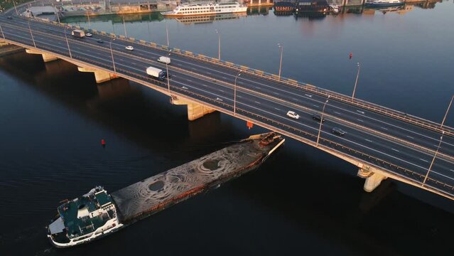 cargo barge floats on the river, morning haze, fog over the water. the copter flies over the cargo riverboat in the afternoon. drone filming from above the river in the city