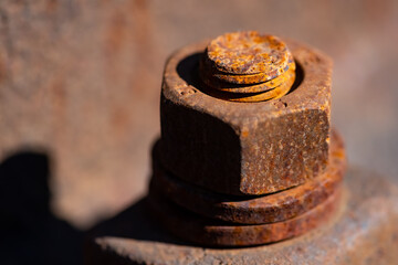Rusty corroded iron screw with washer and thread vertical on a railway profile. Monochrome orange...