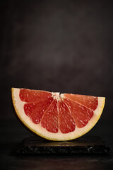 a piece of grapefruit on a dark background