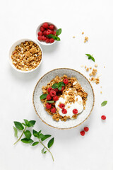 Granola with white plain yogurt and fresh raspberry in a bowl, healthy food for breakfast, top view