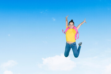 Happy female student jumping on blue sky