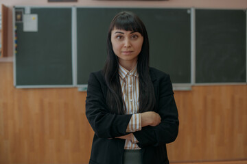 Portrait of a young teacher at the blackboard at school