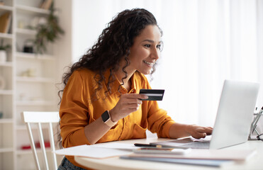 Businesswoman Shopping Online Using Credit Card And Laptop At Workplace - obrazy, fototapety, plakaty