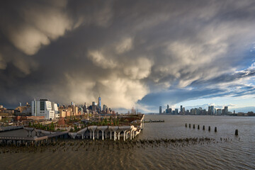 Passing storms over Manhattan at sunset along Hudson River Park. Views on West Village, World Trade...