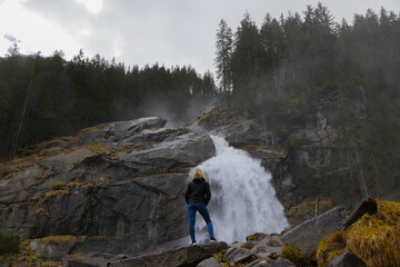 Person atmet die Wassergischt am Wasserfall