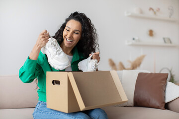 Happy Female Buyer Unpacking Cardboard Box With Delivered Shoes Indoors