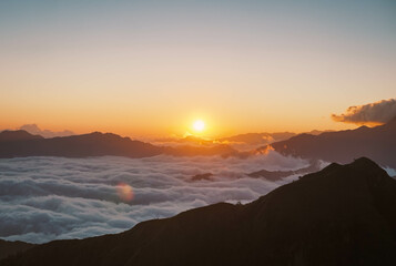 Breath taking view of sunrise on the sea of clouds after a hard climb gives feeling of serenity, stillness  and mindfulness. 