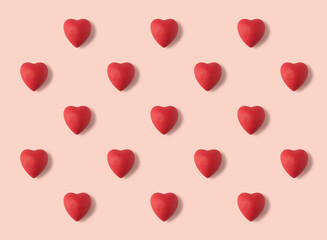 Plasticine hearts arranged in a pattern on a pink background. Handmade hearts from plasticine. 3d artwork