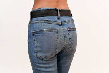 Buttocks of a girl in jeans close-up. Half-turn view from behind.