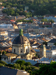 Fototapeta na wymiar Top view of the roof of an old European city - Lviv. Old architecture, old metal rusted roofs, view of the city from the town hall at sunset. View of an old European city from a height 