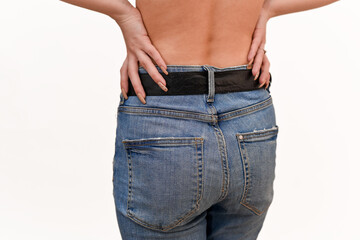 Buttocks of a girl in jeans close-up. Hands on the lower back. Close-up from behind.