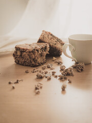 Piece of cake with apple and walnuts accompanied with a cup of coffee and pieces of muesli