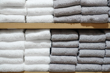 棚に積まれた白とグレーの2色のタオル